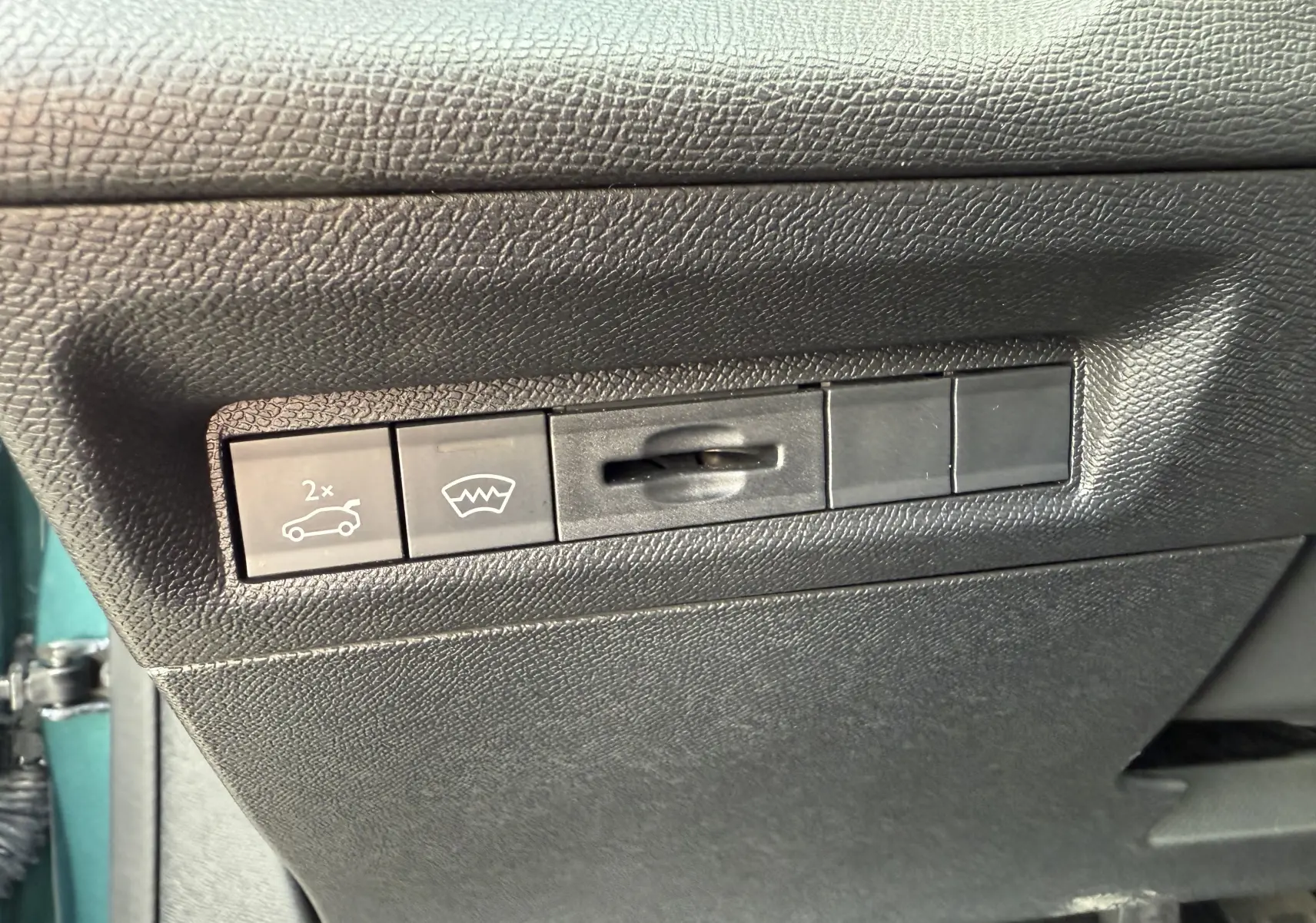 Panneau de commandes intérieures noires avec boutons de coffre et dégivrage, sur Peugeot 308 SW Bleu Avartar 2024.