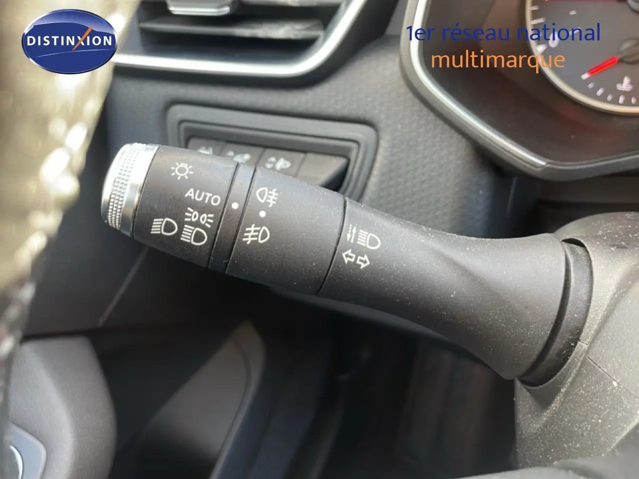 Gros plan sur la commande des feux et clignotants à gauche du volant dans une Renault Clio blanc glacier 2020.