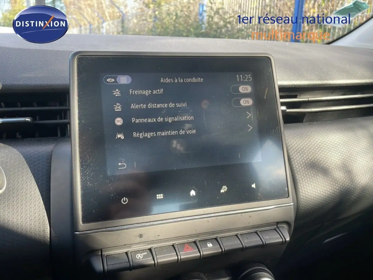 Écran tactile central du tableau de bord de la Renault Clio blanc glacier 2020, affichant les aides à la conduite.