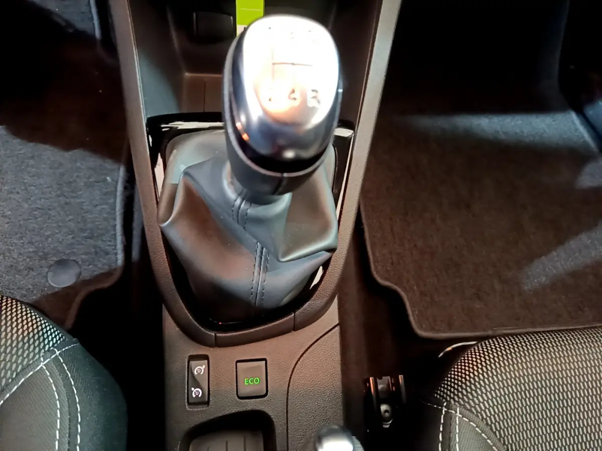 Vue rapprochée du levier de vitesses manuel et des boutons Eco dans l'habitacle noir de la Renault Clio Business gris clair.