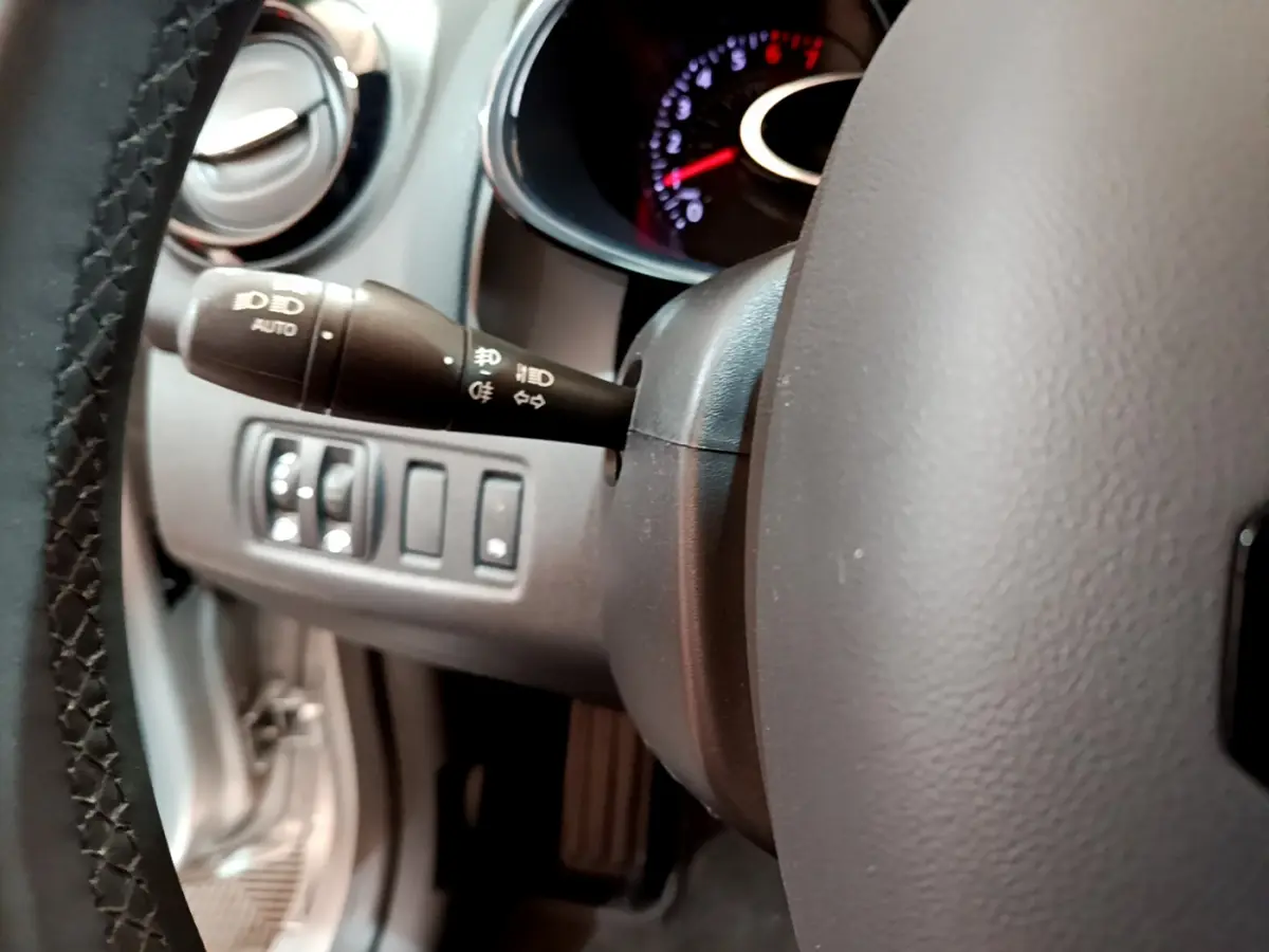 Gros plan sur le volant cuir et la commande des phares à gauche du tableau de bord de la Renault Clio Business gris clair 2019.