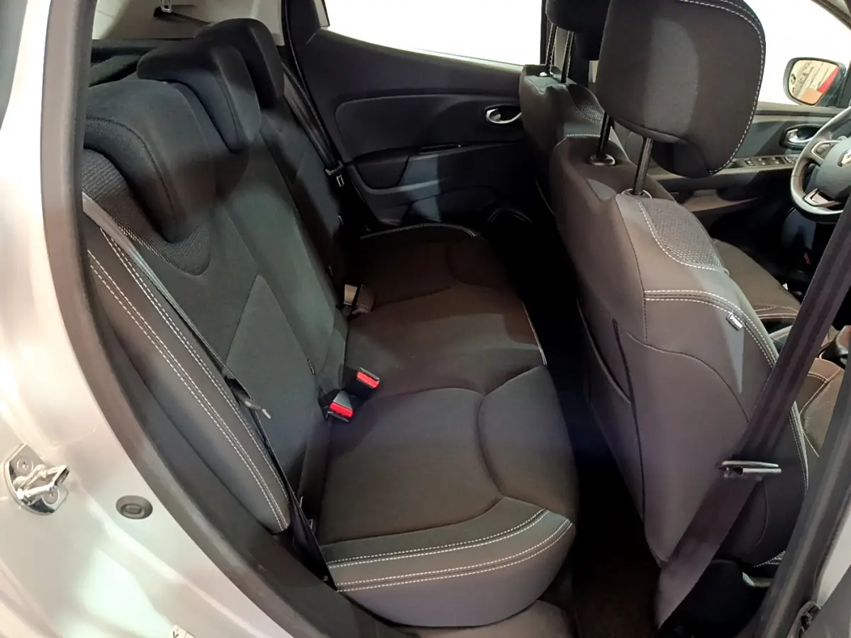 Vue intérieure côté gauche arrière de la Renault Clio Business gris clair, sièges noirs avec surpiqûres blanches visibles.