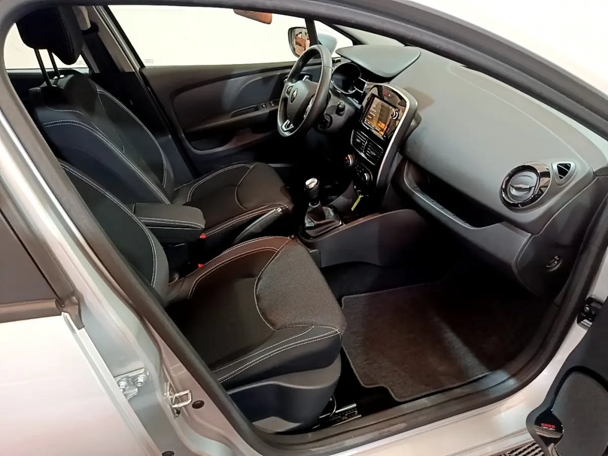 Intérieur noir vu côté conducteur d'une Renault Clio Business TCe 90 2019 avec tableau de bord tactile et boîte manuelle.