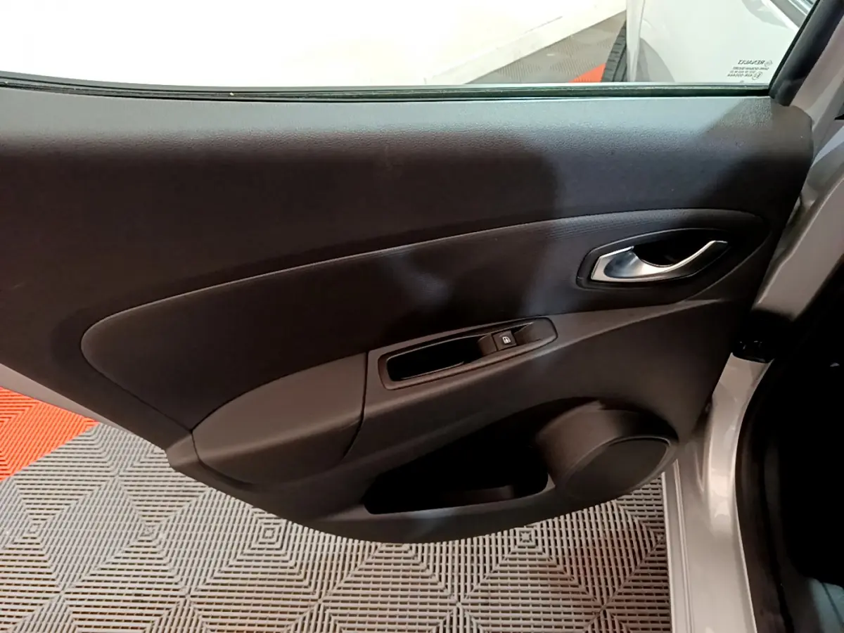 Vue intérieure de la porte avant droite grise de la Renault Clio Business TCe 90 avec poignée et commande de vitre.