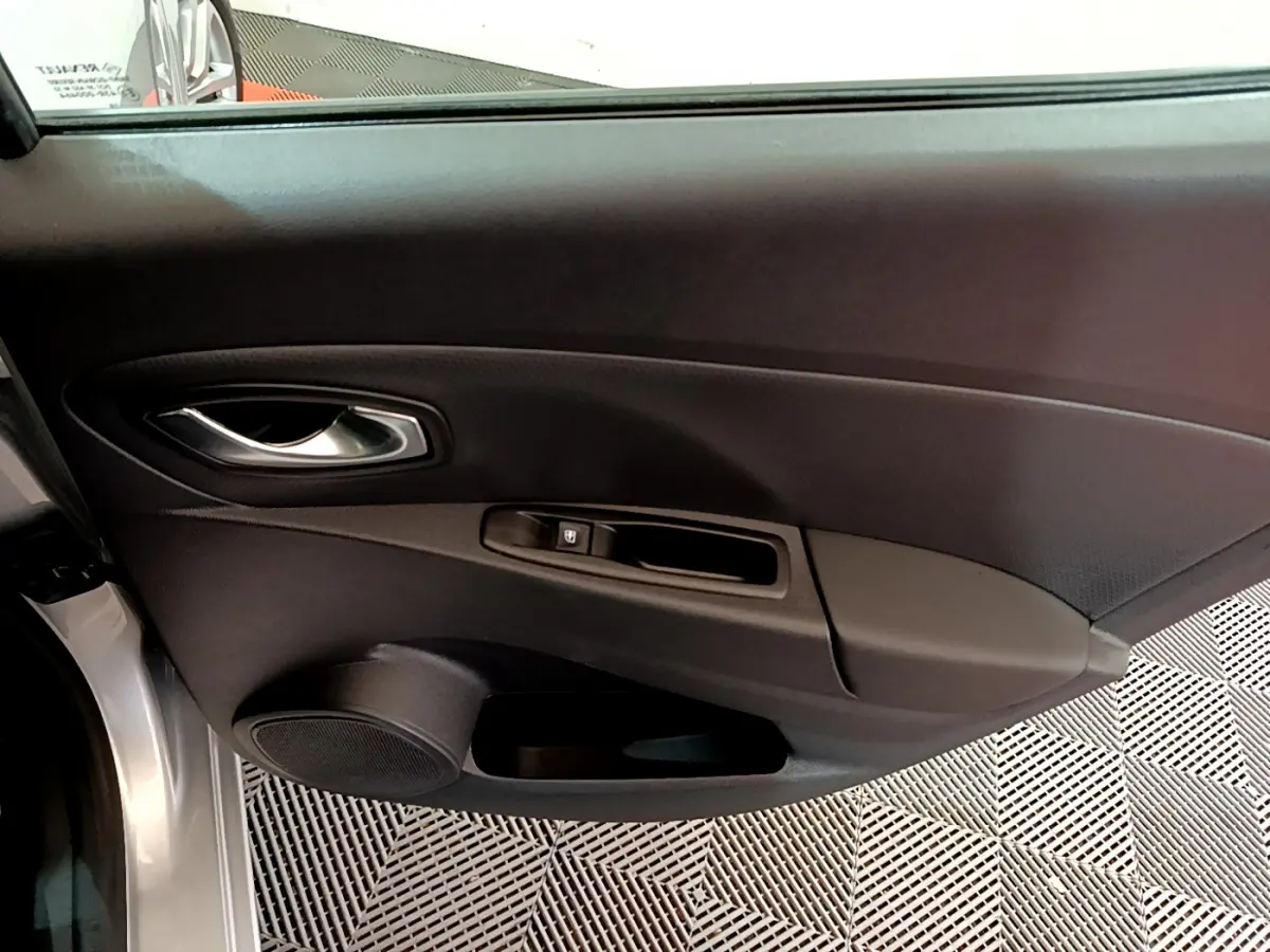 Porte intérieure côté gauche de Renault Clio Business TCe 90 gris clair, avec poignée argentée et commande de vitre électrique.