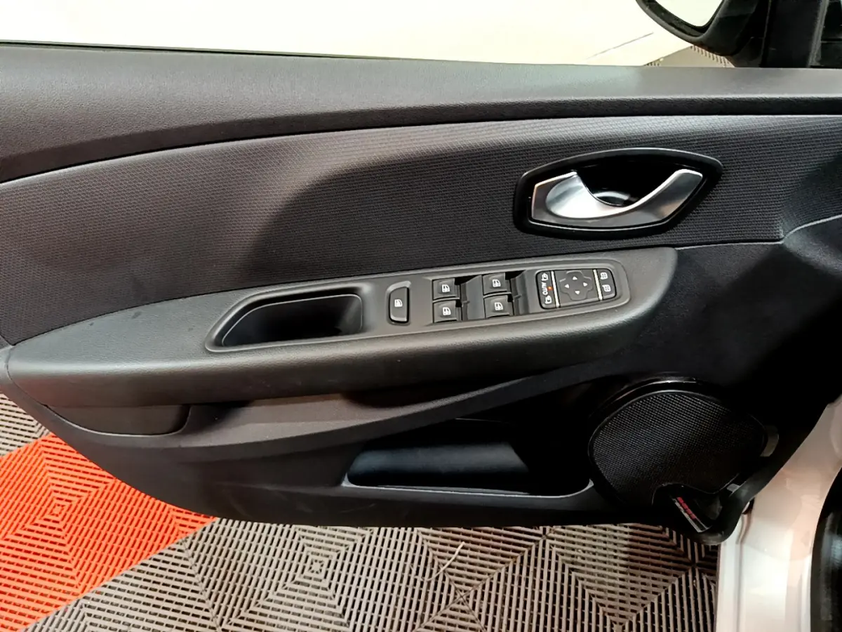 Vue rapprochée de la porte côté conducteur de la Renault Clio Business TCe 90 gris clair avec commandes électriques et haut-parleur intégré.