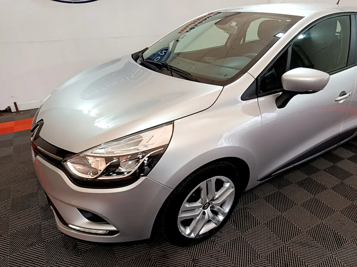 Renault Clio Business TCe 90 gris clair vue 3/4 avant droit, avec phares LED et jantes alliage visibles.