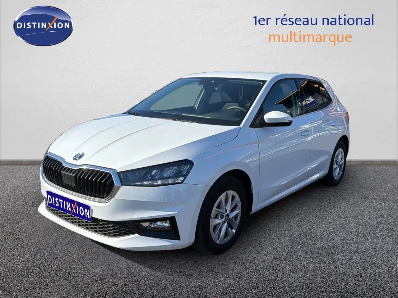 Vue 3/4 avant droite d'une Skoda Fabia blanche glacier, avec calandre noire et jantes alliage 15 pouces.