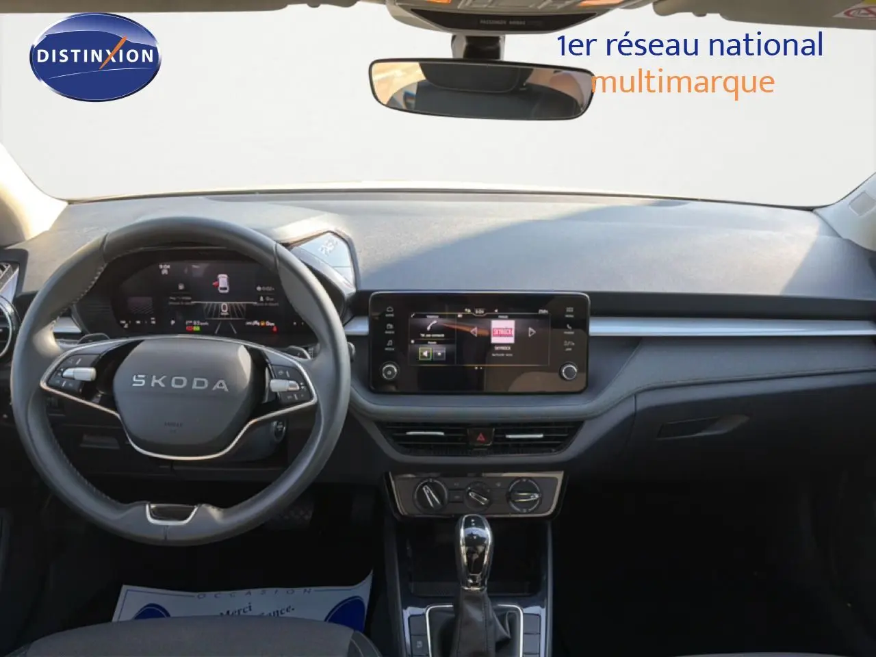 Vue frontale de l’habitacle de la Skoda Fabia blanc glacier 2025, avec tableau de bord numérique et écran tactile central.