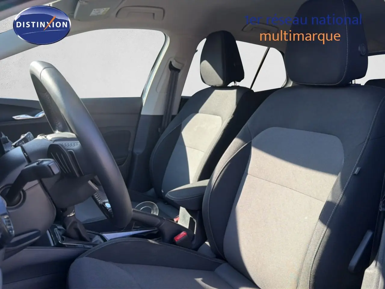 Vue intérieure côté gauche montrant les sièges tissu noir et gris et le volant cuir multifonction d'une Skoda Fabia blanc glacier 2025.