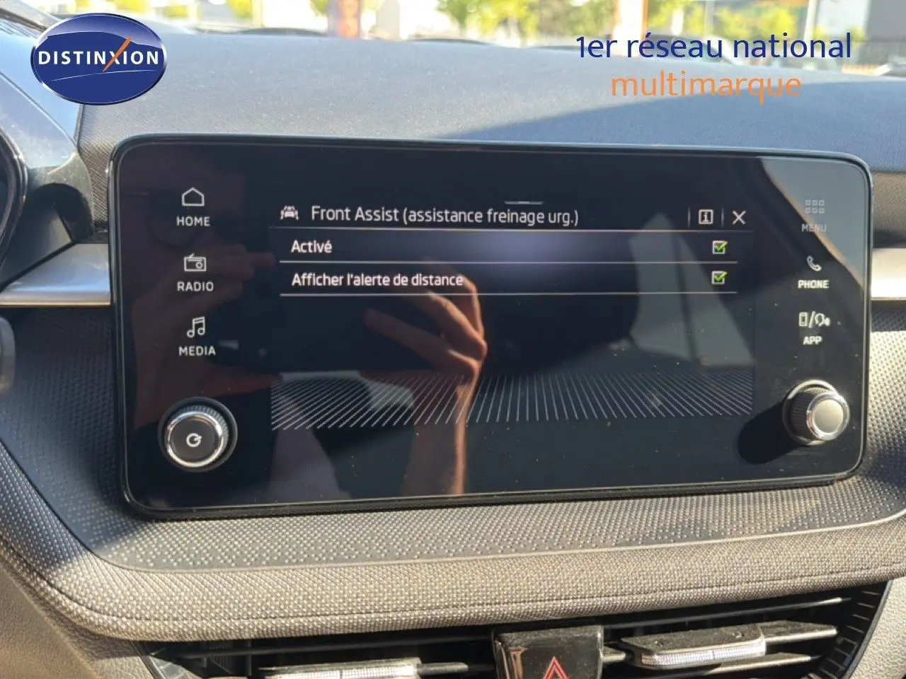 Écran tactile central du Skoda Fabia 2025 montrant l'activation de l'assistance freinage d'urgence, intérieur noir.