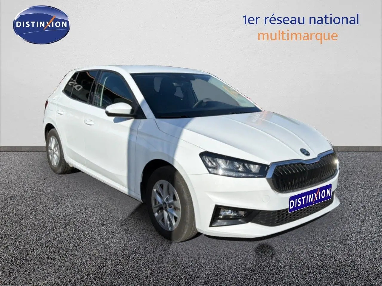 Vue 3/4 avant d'une Skoda Fabia blanche Glacier, avec calandre noire et jantes alliage 15 pouces.
