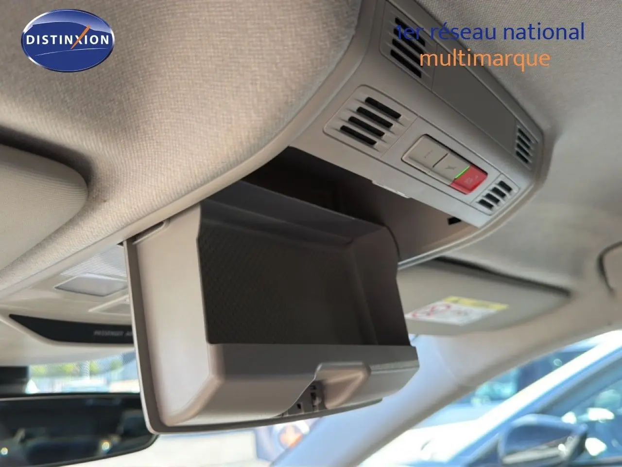 Détail intérieur montrant le rangement lunettes ouvert au plafond d'une Skoda Fabia blanc glacier, avec commandes intégrées.