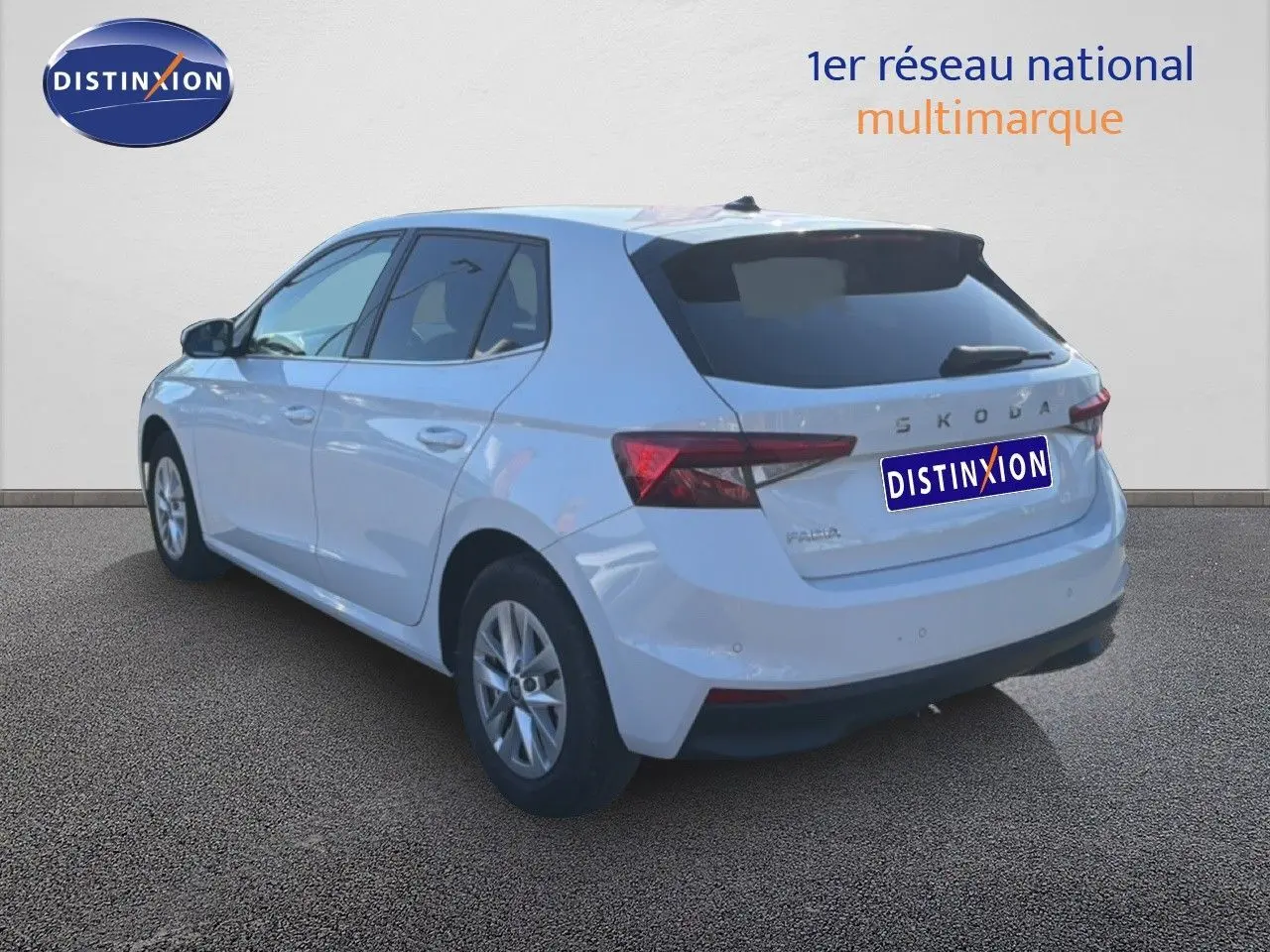 Vue 3/4 arrière droite d'une Skoda Fabia blanche glacier 2025 avec feux arrière LED et jantes alliage 15 pouces.