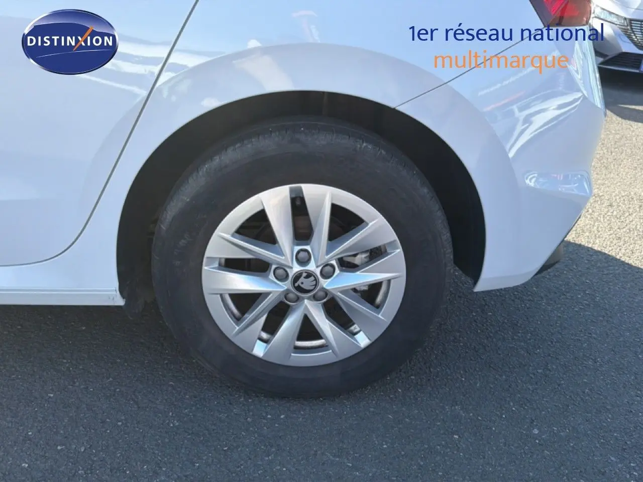 Gros plan sur la roue arrière droite d'une Skoda Fabia blanche glacier avec jante alliage et partie arrière visible.