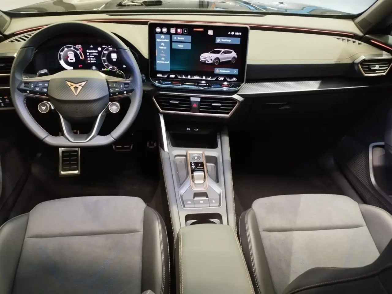Vue intérieure avant de la CUPRA Formentor 2026, tableau de bord noir avec écran tactile HD et volant Supersports cuir.