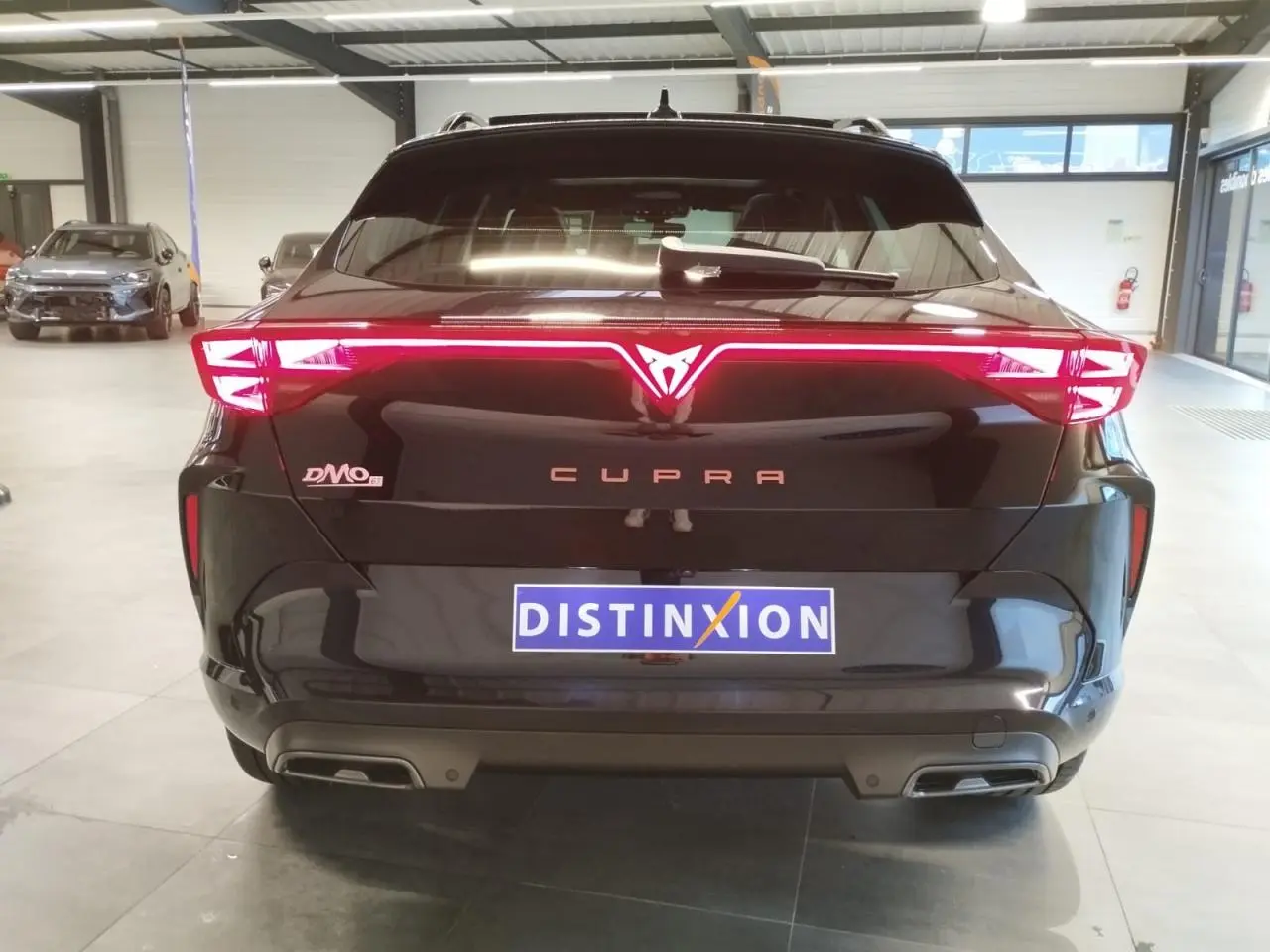 Vue arrière d'une CUPRA Formentor noir métal avec feux arrière Tri-LED et logo CUPRA lumineux au centre.
