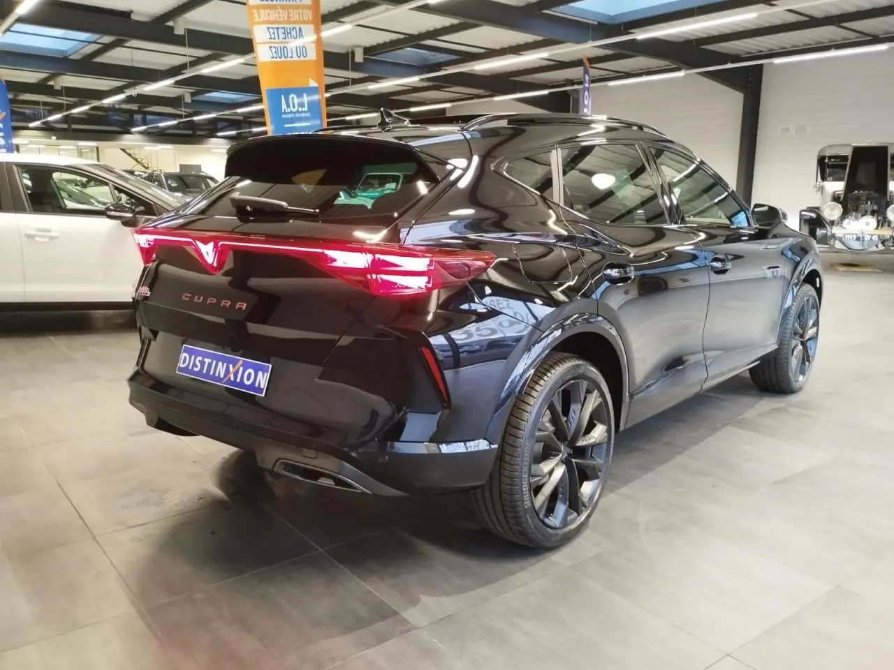 Vue 3/4 arrière droite de la CUPRA Formentor noire métal avec feux arrière Tri-LED et jantes alliage 19 pouces.
