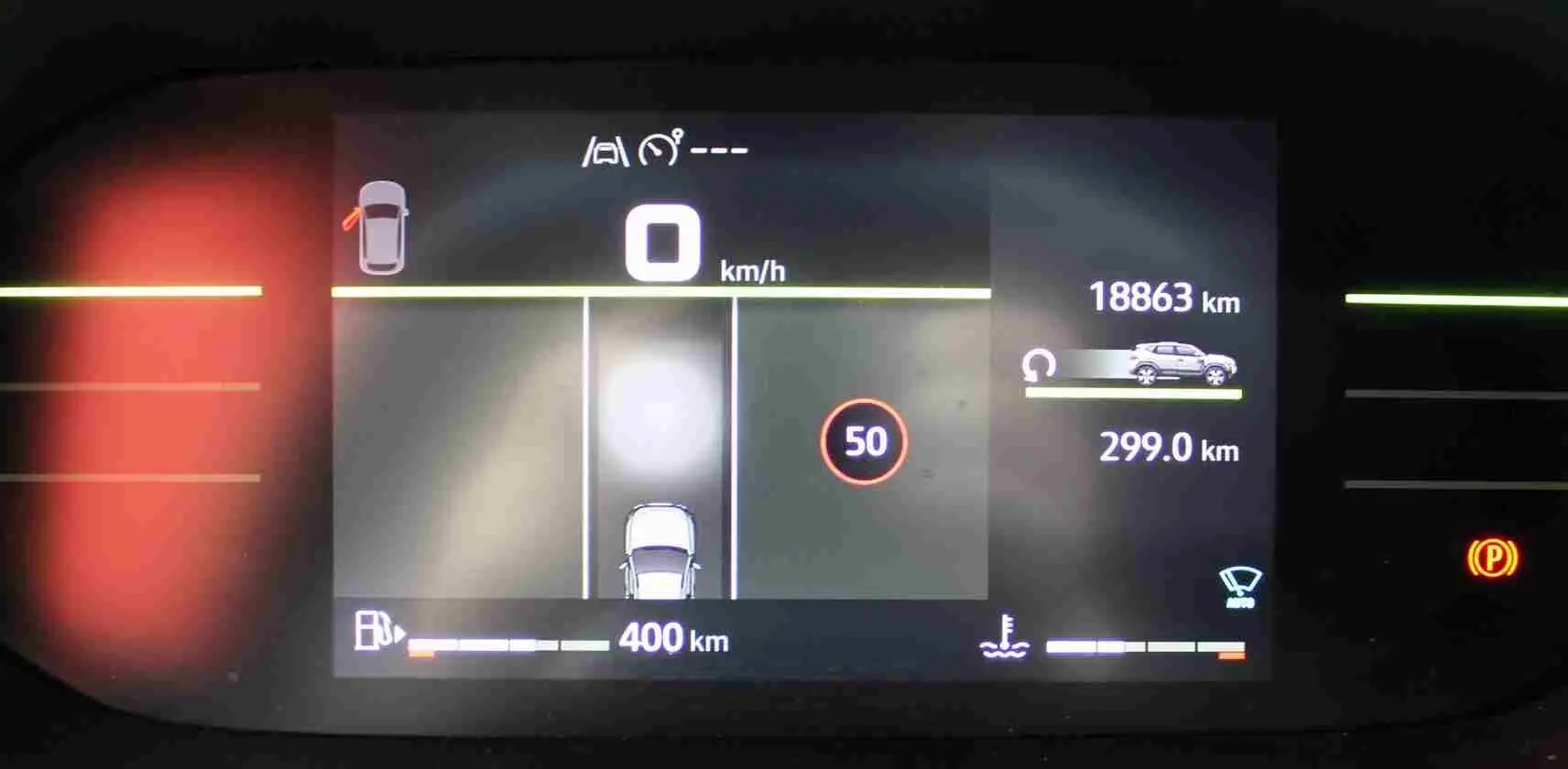 Tableau de bord digital du Dacia Duster 2025 affichant la vitesse, autonomie et alertes, vue de face.