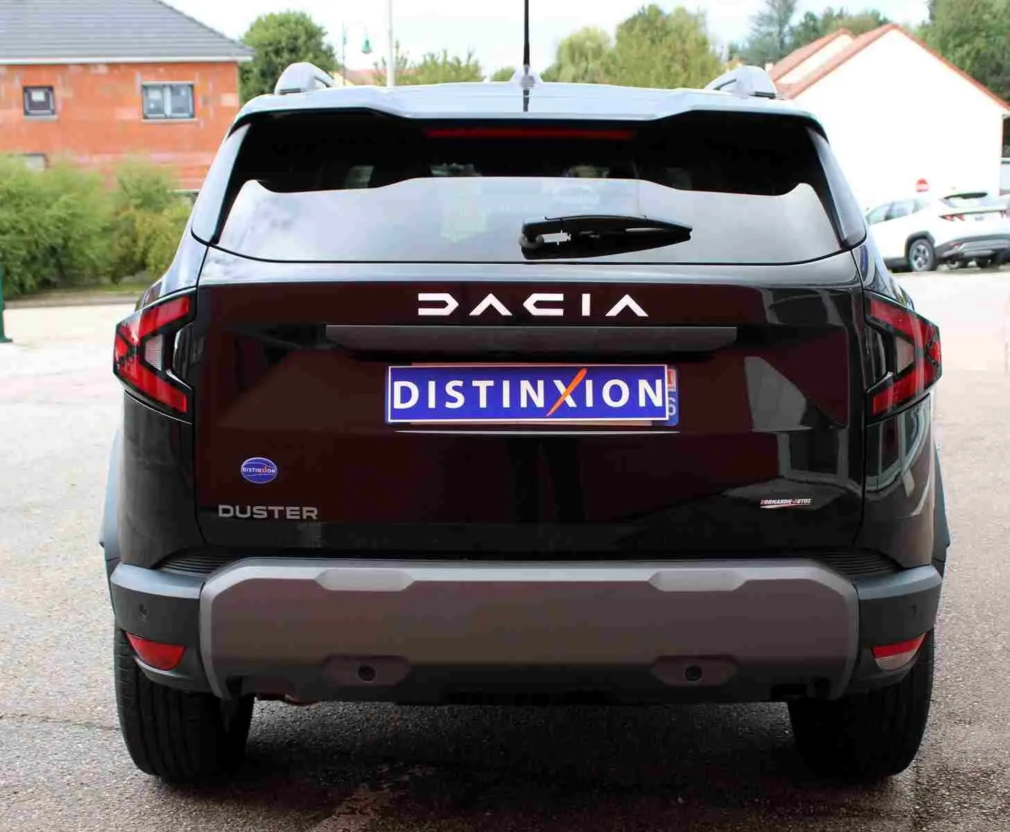 Vue arrière d'un Dacia Duster noir avec logo DACIA lumineux et plaque d'immatriculation Distinxion.