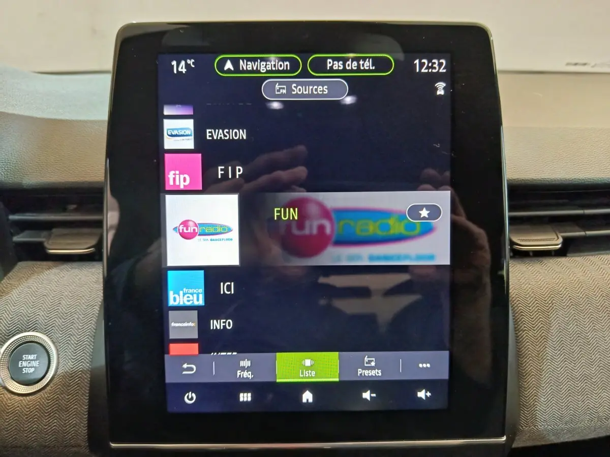 Écran tactile central de la Renault Clio Techno TCe 90 2024 affichant les stations radio avec bouton démarrage visible à gauche