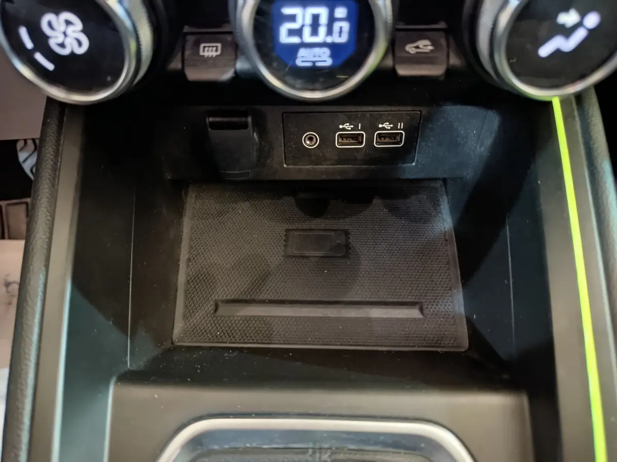 Vue rapprochée de la console centrale noire de la Renault Clio Techno TCe 90 avec ports USB et commandes climatisation.