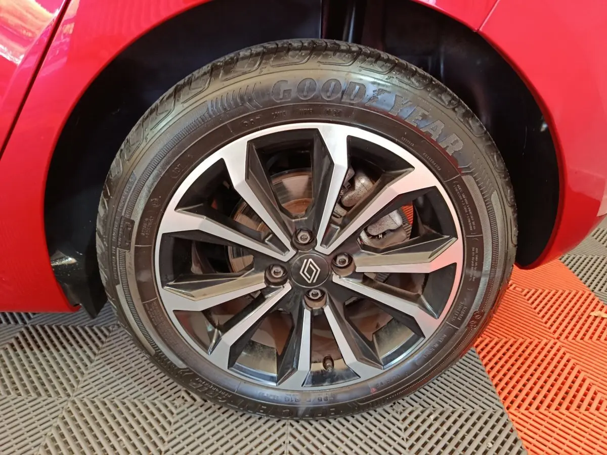 Gros plan sur la roue avant droite rouge de la Renault Clio Techno TCe 90 avec jante alliage noire et argentée.