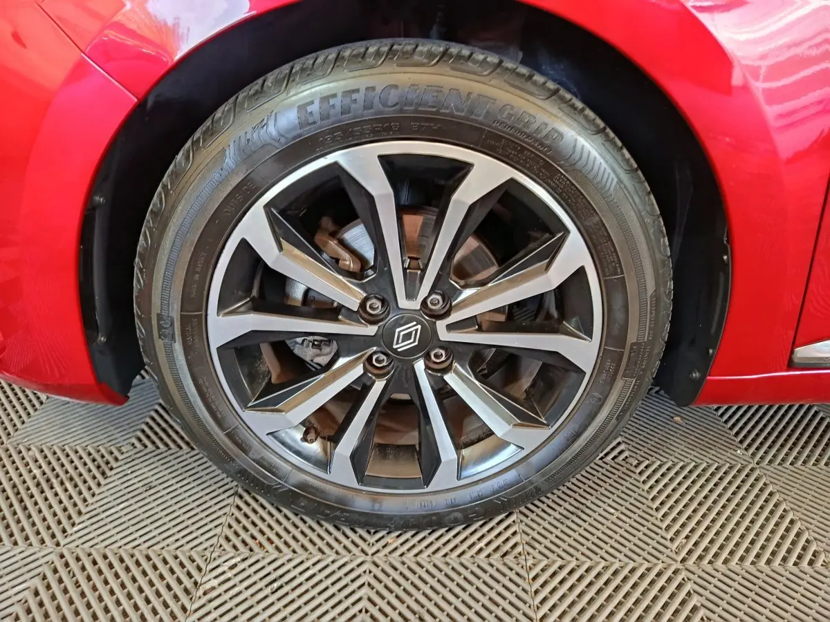 Gros plan sur la roue avant gauche de la Renault Clio Techno TCe 90 rouge, avec jante alliage au design moderne.