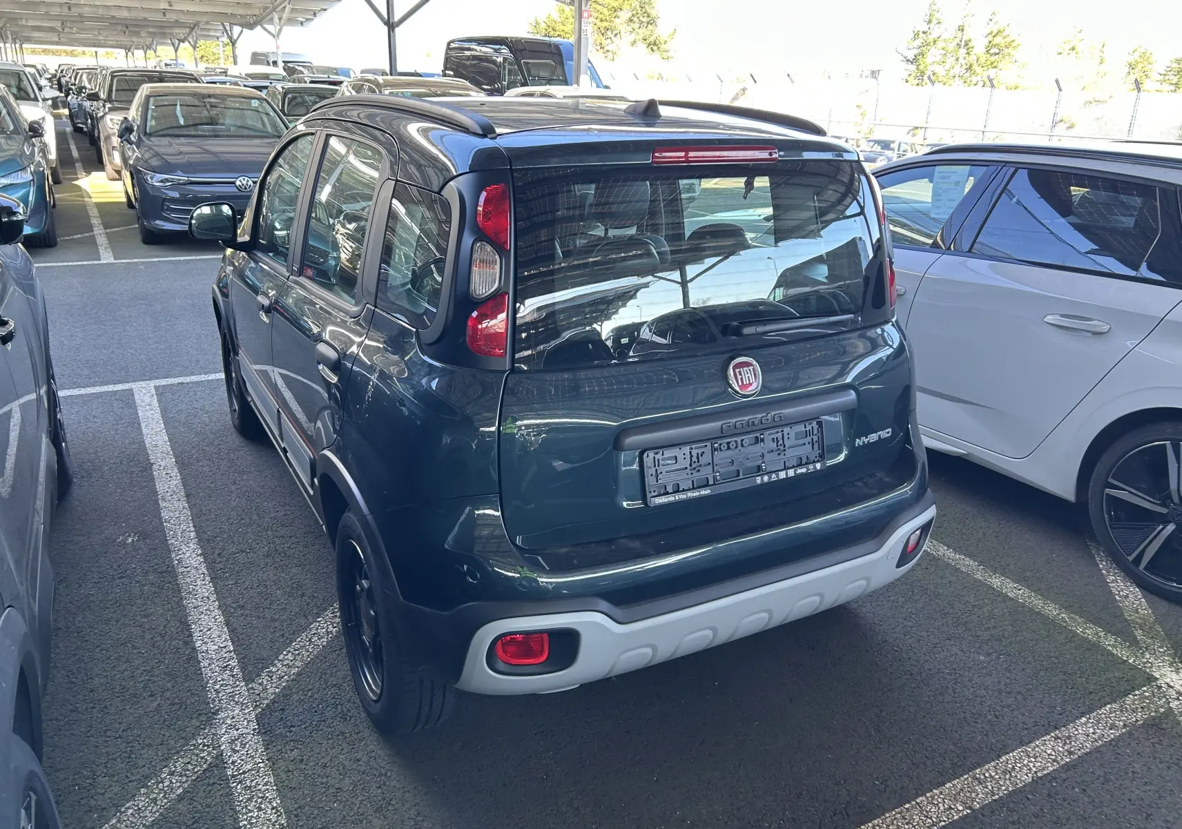 Vue 3/4 arrière droite d'une FIAT Panda City Cross 2023 gris minuit avec protections noires et jantes noires.
