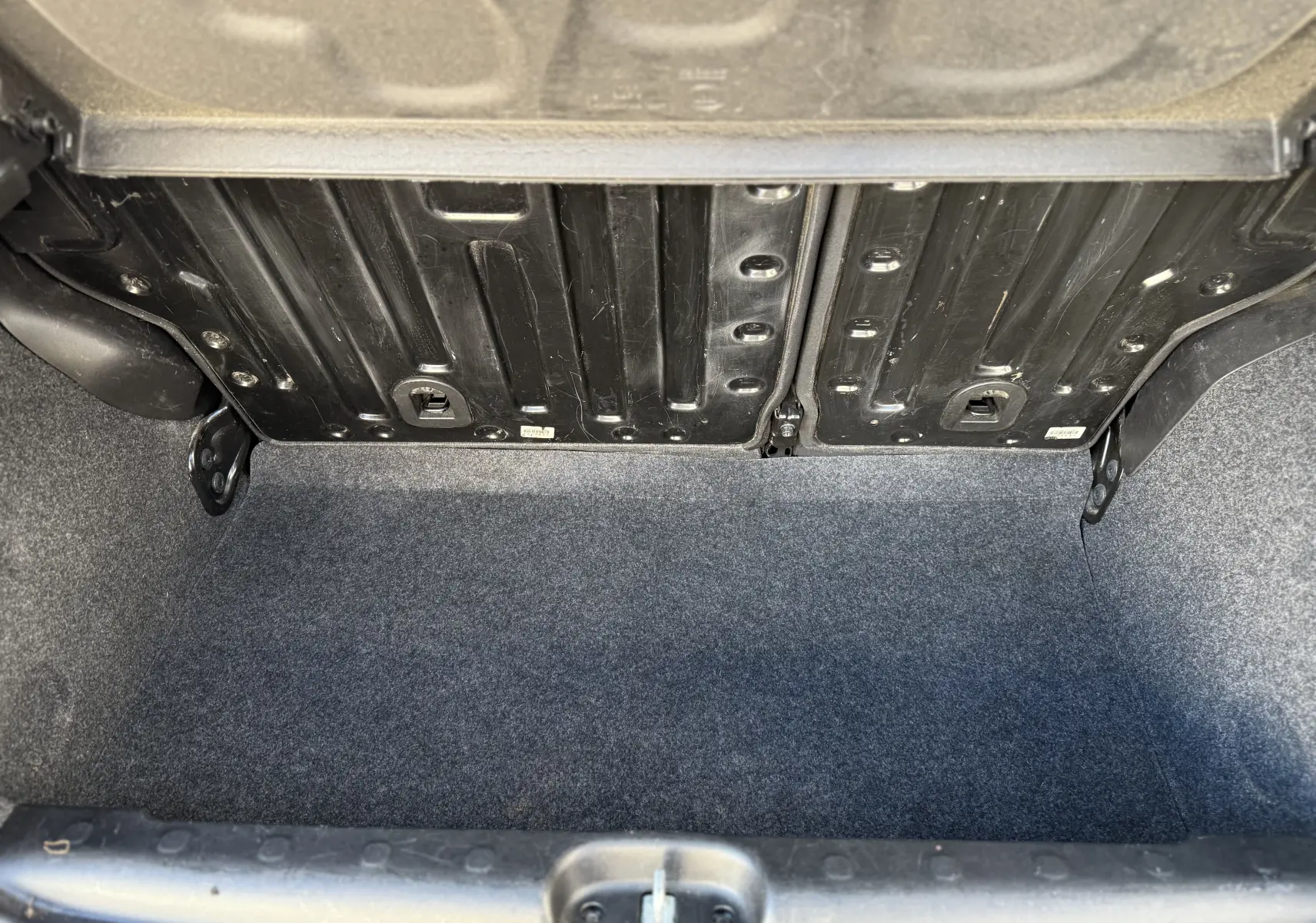 Vue intérieure du coffre vide de la Fiat Panda City Cross 2023, avec revêtement gris et structure métallique apparente.