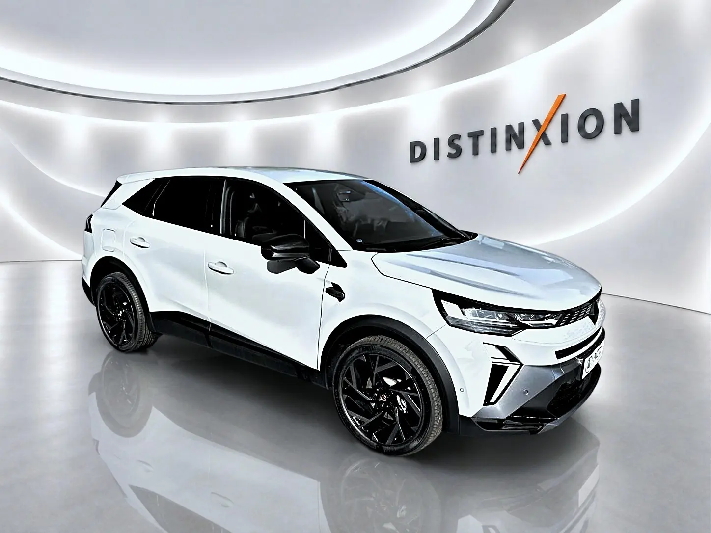Vue 3/4 avant droite d'un Renault Symbioz gris cassiope avec jantes noires dans un showroom moderne.