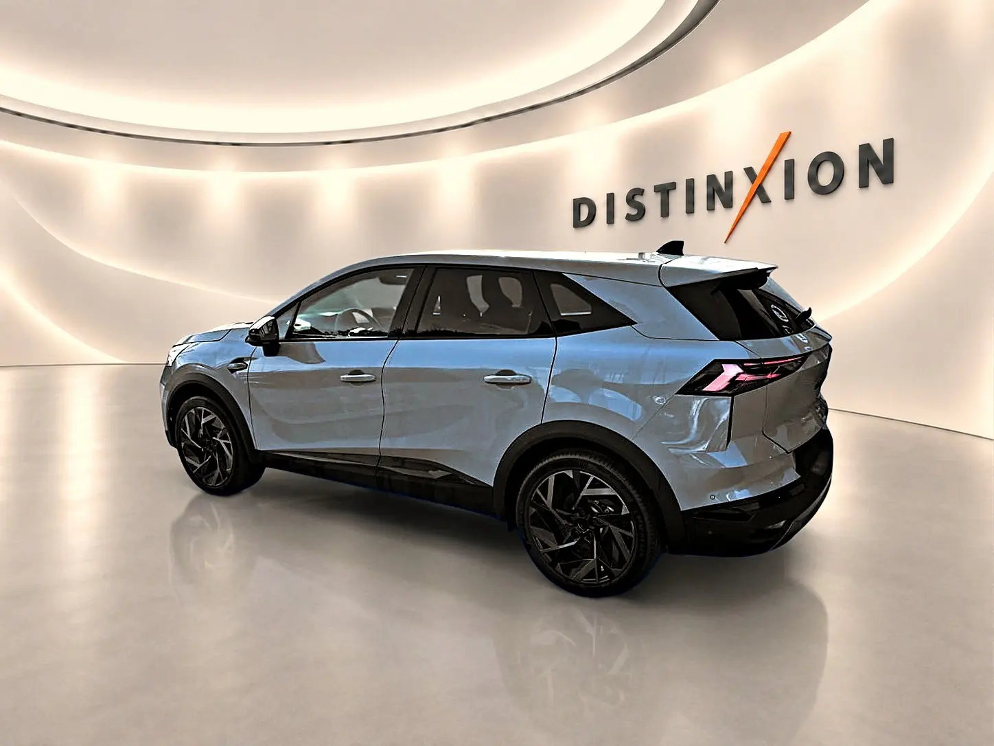 Renault SYMBIOZ gris cassiope en 3/4 arrière droit dans un showroom lumineux avec jantes noires distinctives.