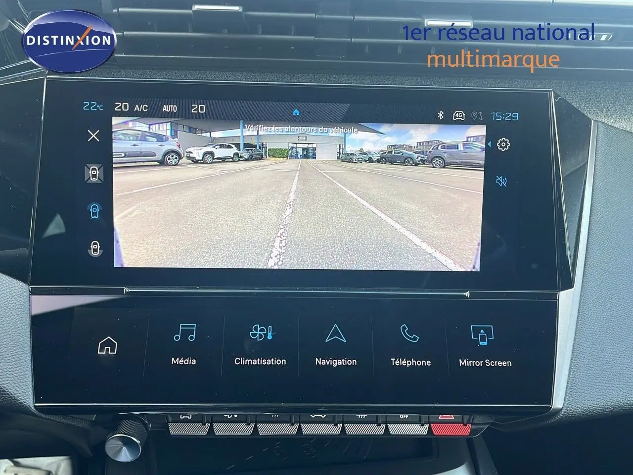 Écran tactile intérieur de la Peugeot 308 hybride affichant la caméra de recul avec vue dégagée sur un parking.