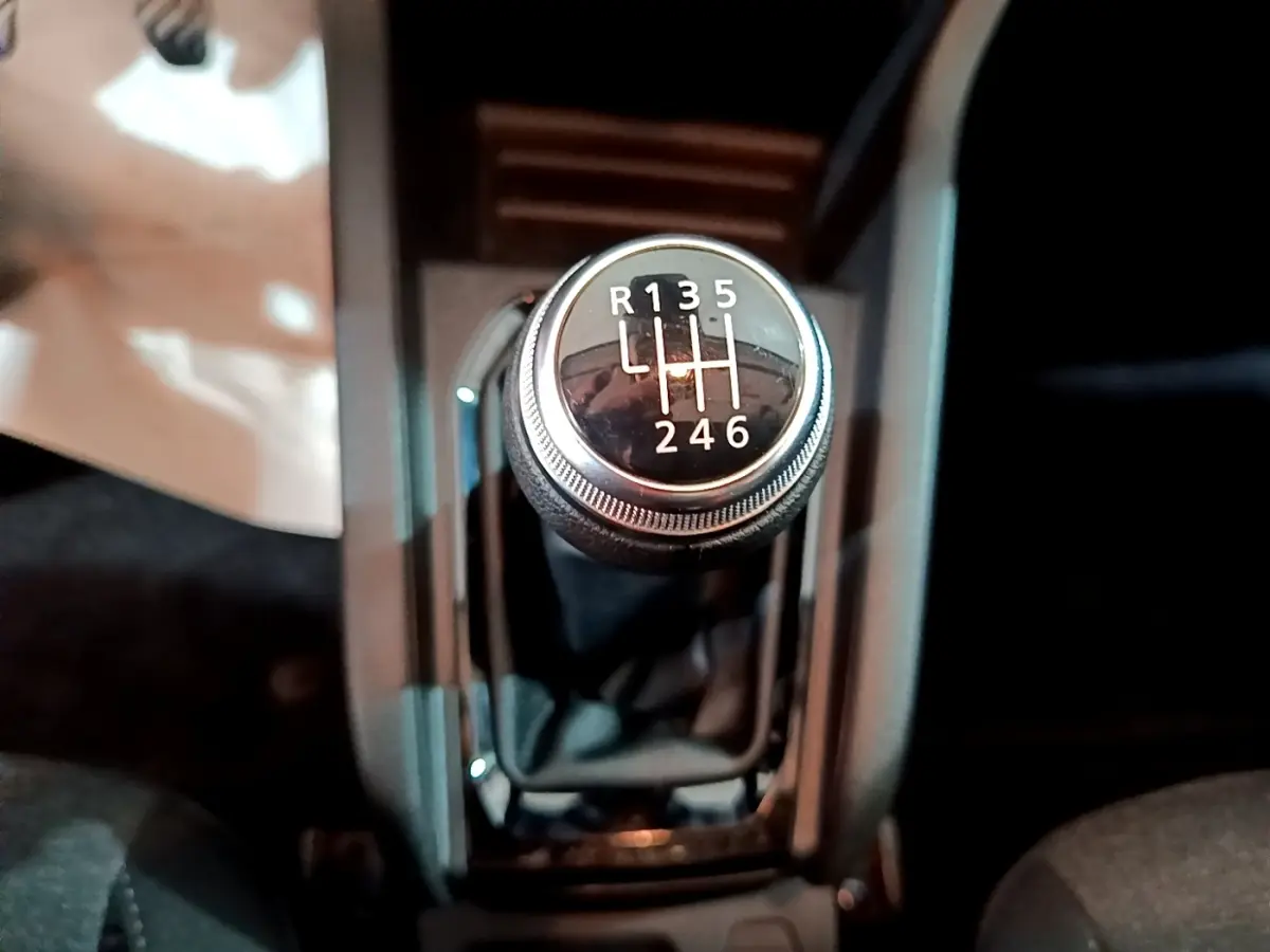 Le levier de vitesses manuel noir de la Renault Clio Business TCe 90, vu de dessus dans l'habitacle.