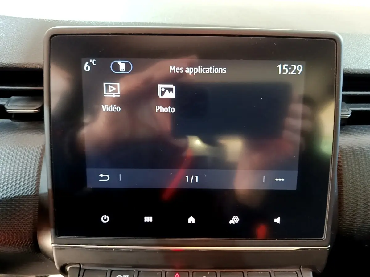 Écran tactile central de la Renault Clio Business gris foncé, affichant le menu applications vidéo et photo.