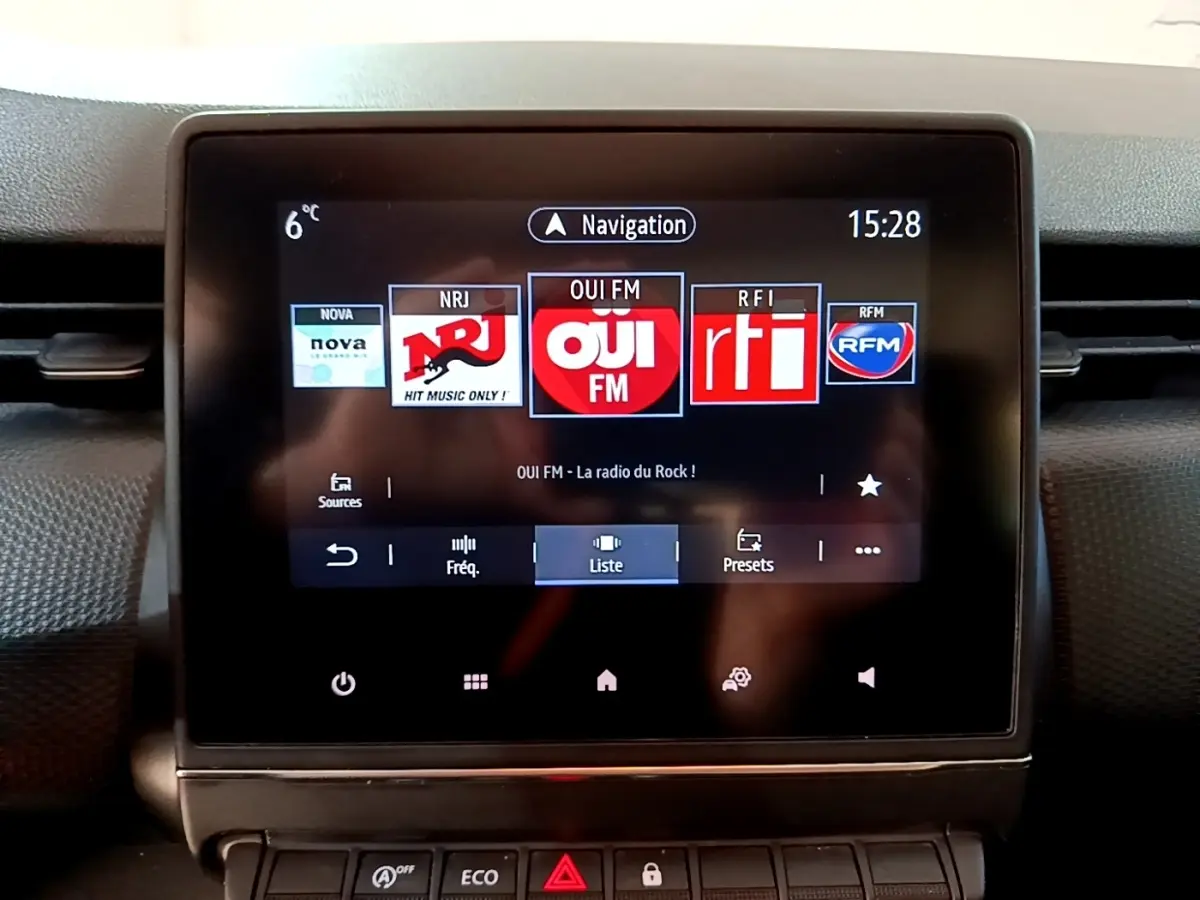 Écran tactile central de la Renault Clio Business TCe 90 2022 affichant les stations radio avec commandes en dessous.