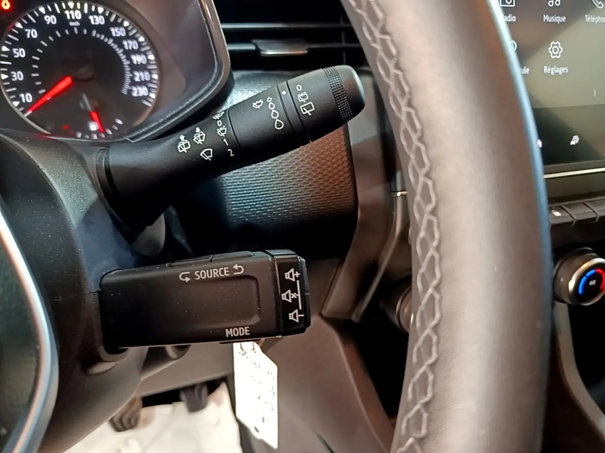 Gros plan sur la commande au volant et le tableau de bord gris foncé de la Renault Clio Business TCe 90 2022.