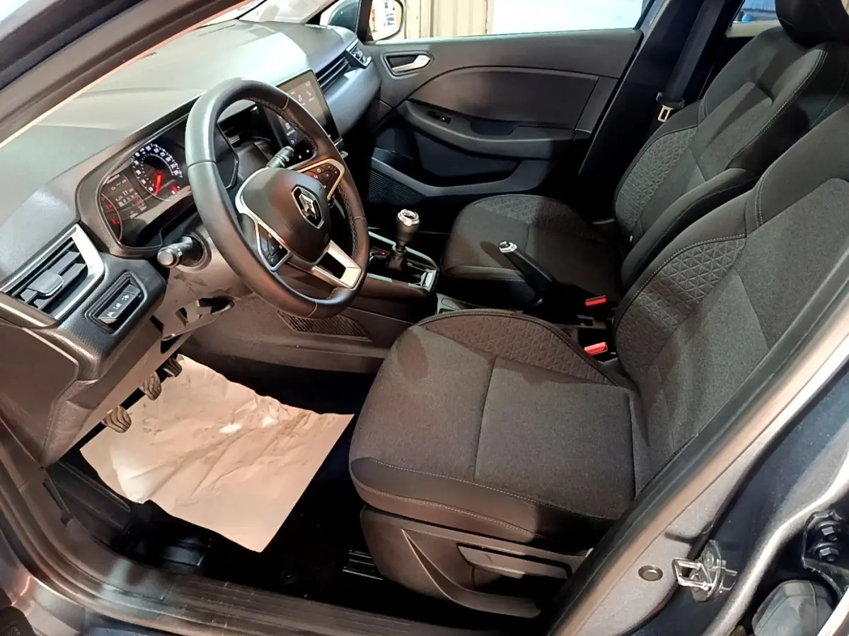 Intérieur de la Renault Clio Business TCe 90 2022 en gris foncé, vue côté conducteur montrant tableau de bord et sièges tissu.