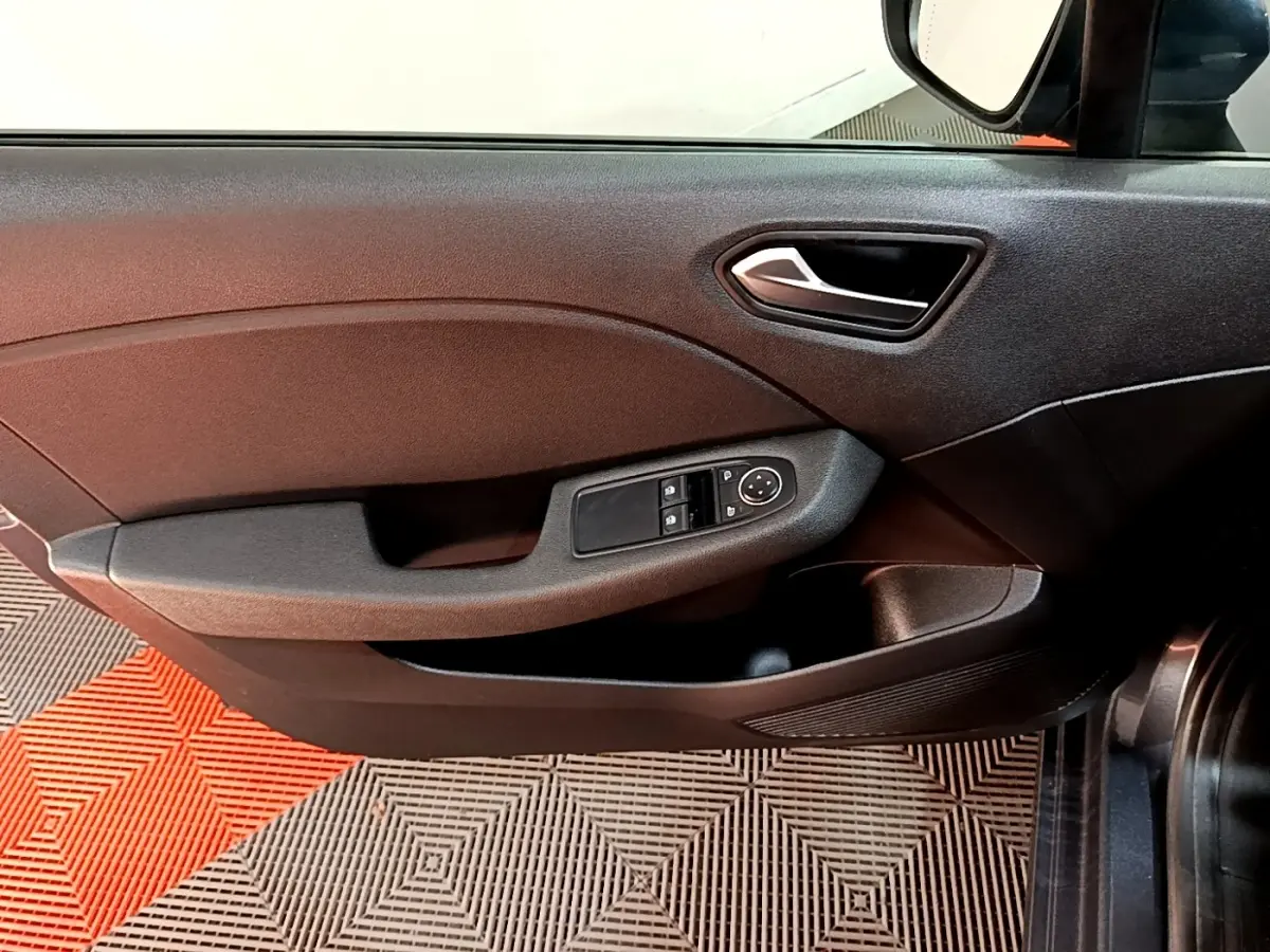 Gros plan sur la porte côté conducteur gris foncé de la Renault Clio Business TCe 90 avec commandes électriques des vitres.