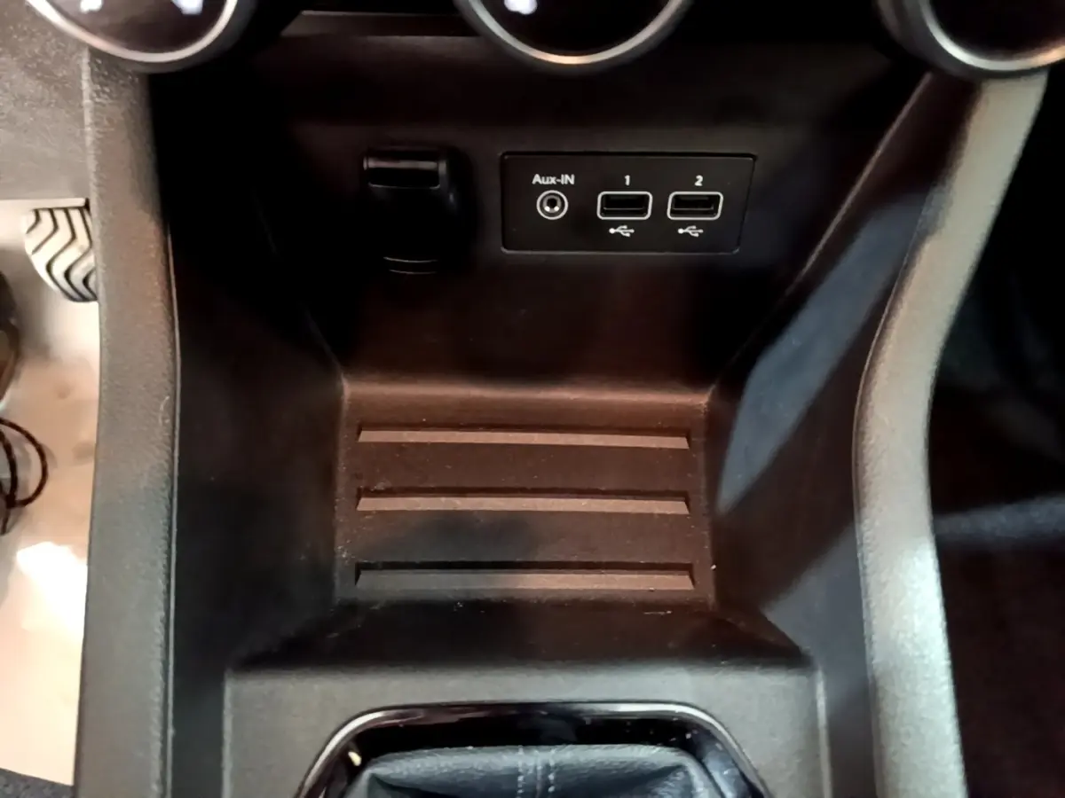 Vue rapprochée de la console centrale noire de la Renault Clio Business TCe 90, montrant ports USB et prise Aux-IN.