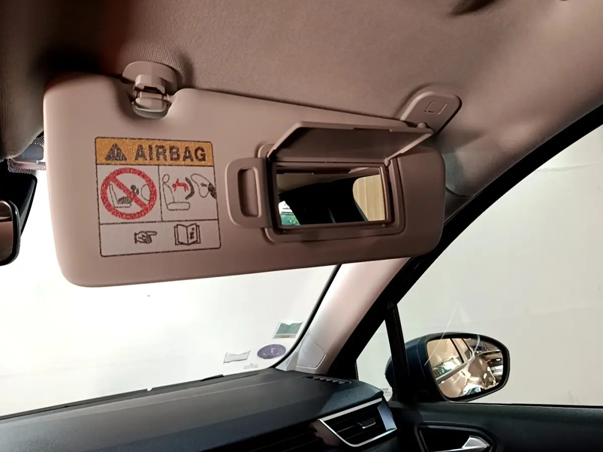 Miroir de courtoisie ouvert sur pare-soleil côté conducteur dans l'habitacle gris foncé d'une Renault Clio Business TCe 90 2022.