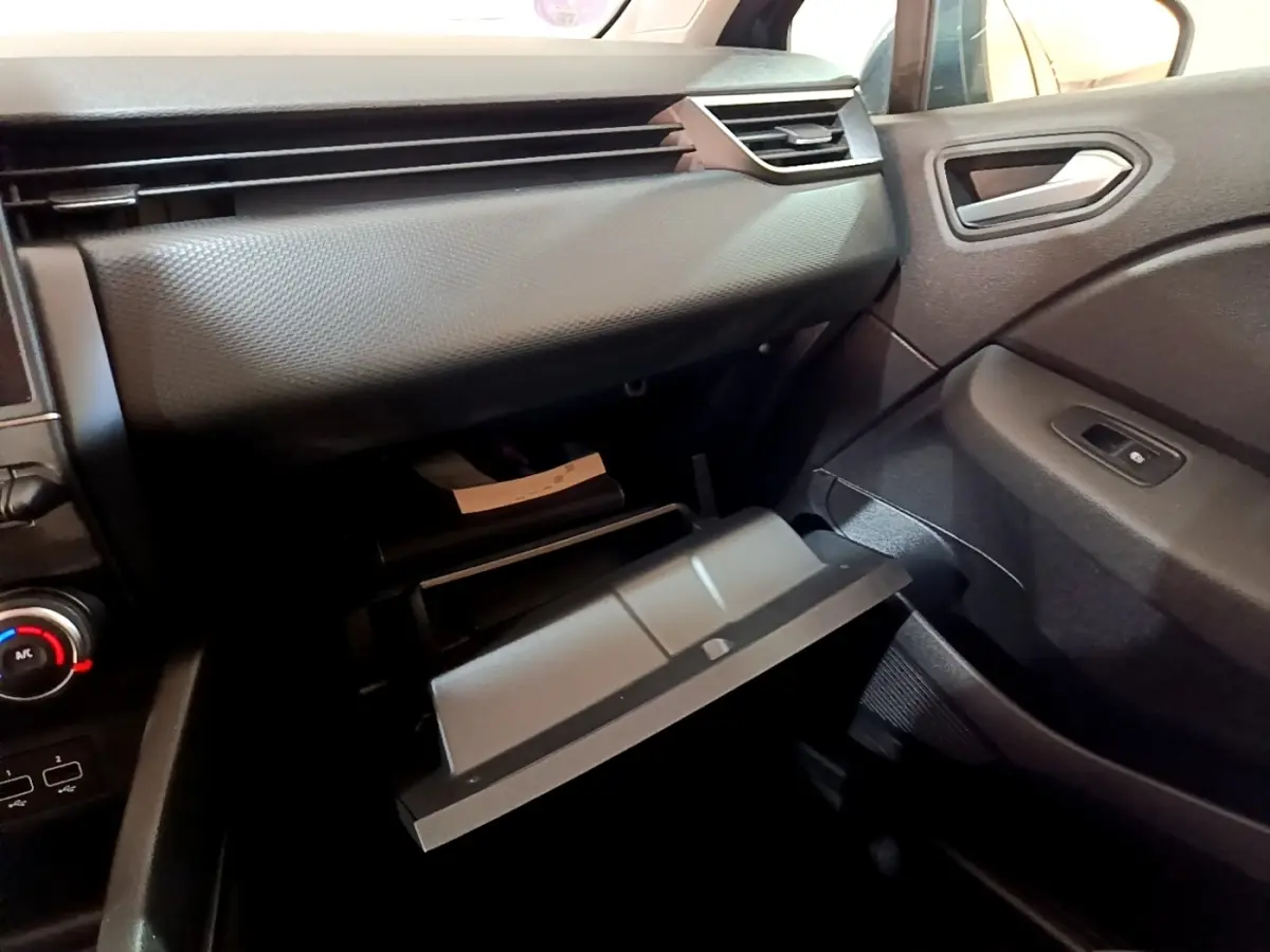 Intérieur de la Renault Clio Business TCe 90 2022, vue côté passager sur la boîte à gants ouverte et tableau de bord gris foncé.