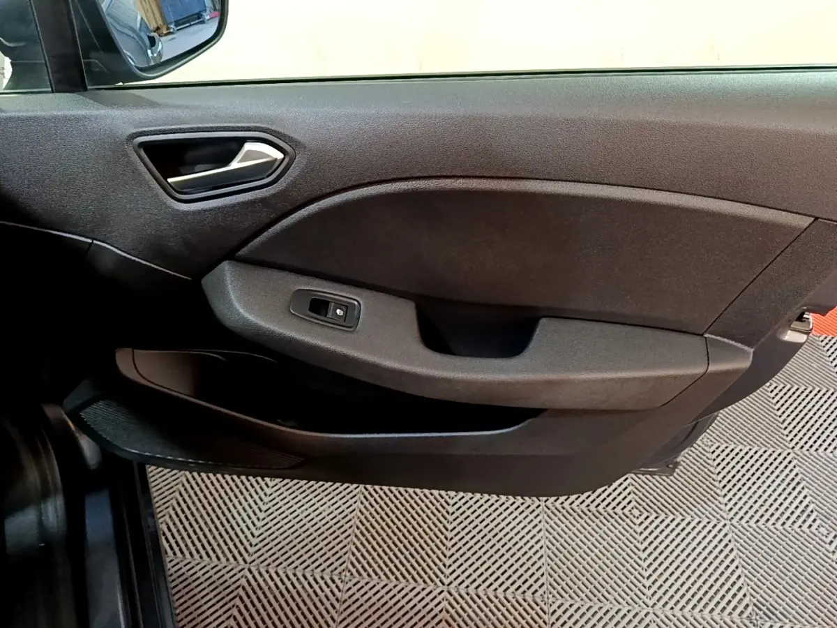 Vue rapprochée de la porte côté conducteur de la Renault Clio Business TCe 90 2022 en gris foncé, avec poignée et commande de vitre.