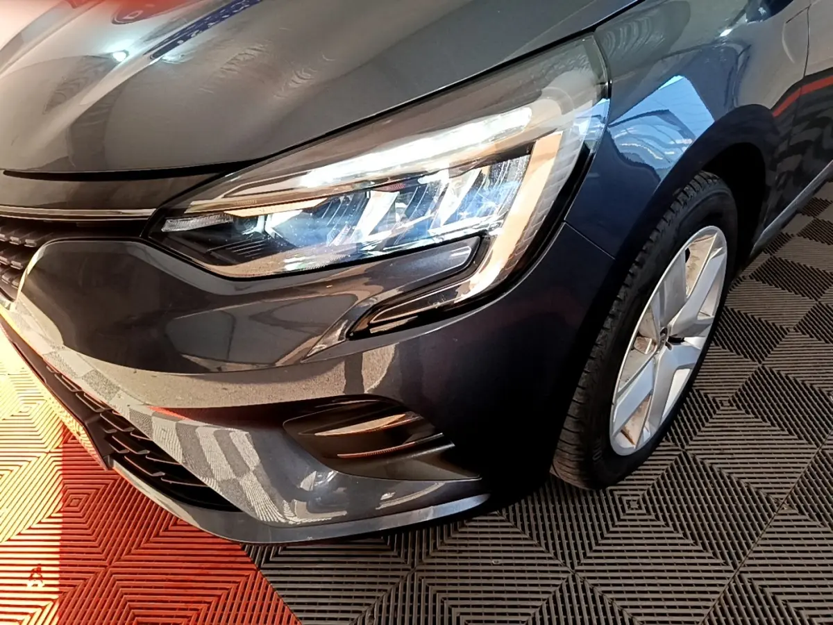 Gros plan sur l'avant droit de la Renault Clio Business TCe 90 gris foncé, mettant en valeur le phare LED et la jante alliage.