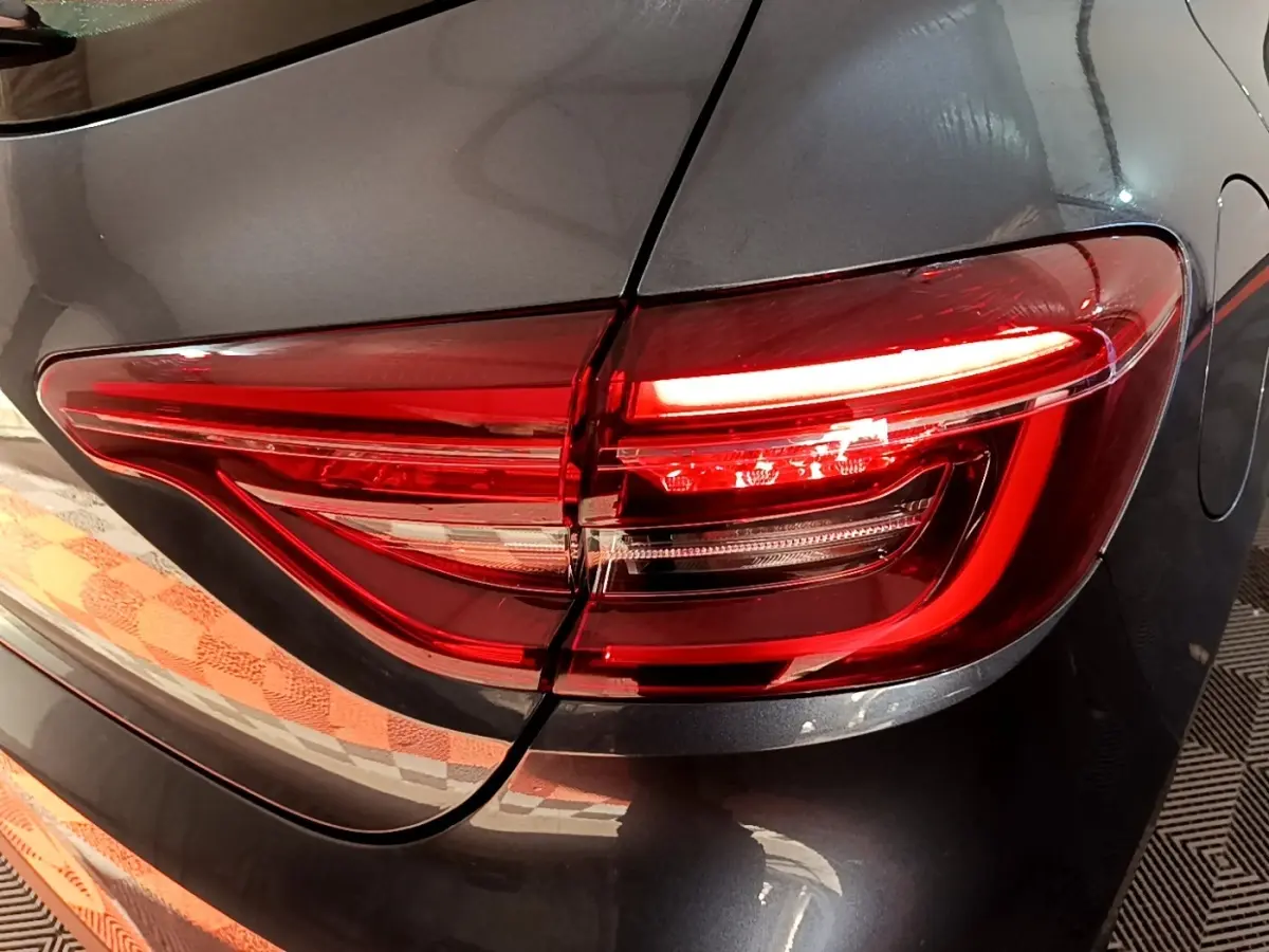 Gros plan sur le feu arrière droit rouge d'une Renault Clio Business gris foncé 2022, avec la trappe à carburant visible.