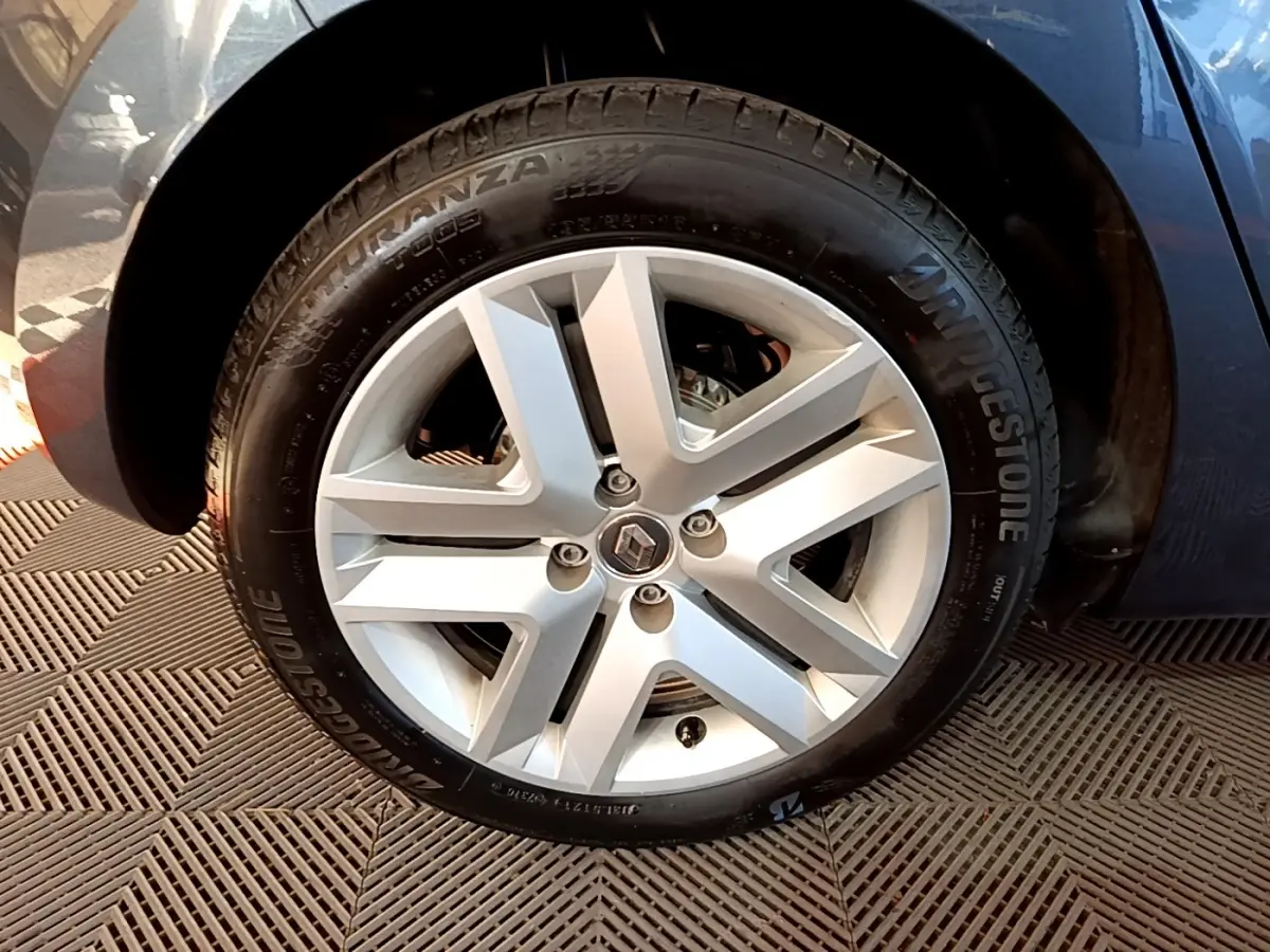 Vue rapprochée de la roue arrière droite d'une Renault Clio gris foncé avec pneu Bridgestone visible.