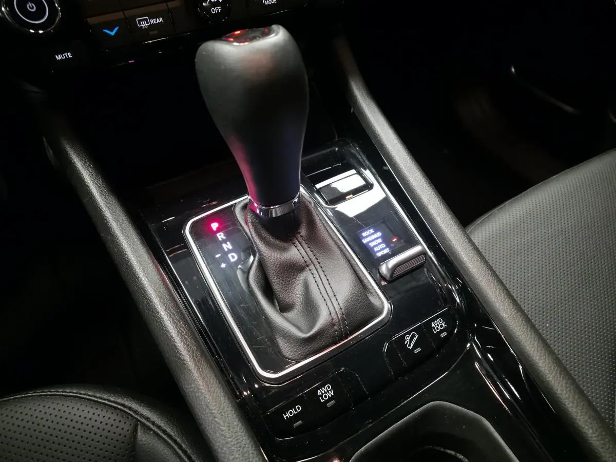 Gros plan sur la console centrale noire du Jeep Compass 2024 avec levier de vitesses automatique et commandes 4WD visibles.