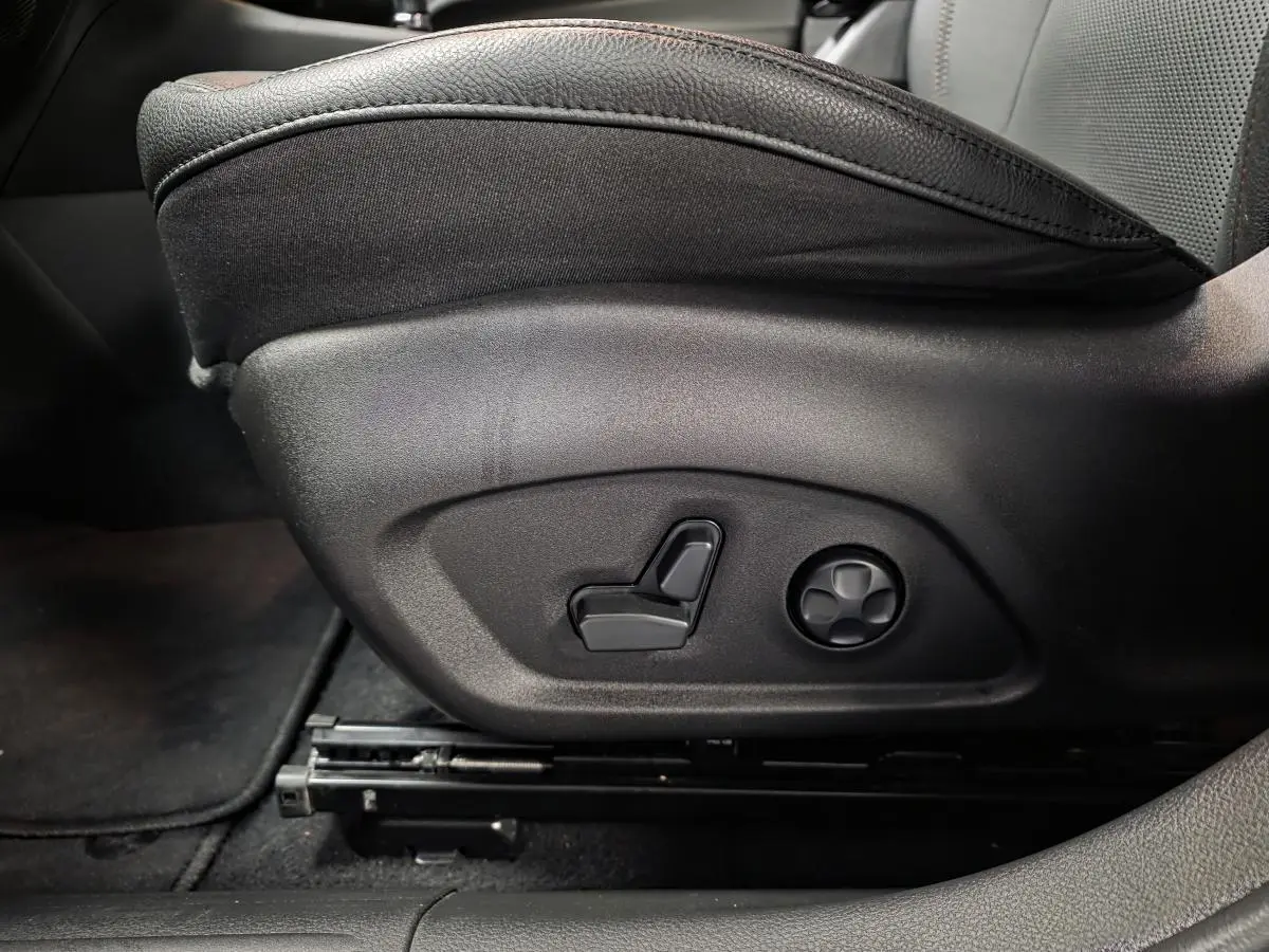 Réglage électrique du siège avant côté gauche sur cuir noir avec surpiqûres rouges du Jeep Compass Trailhawk 2024.