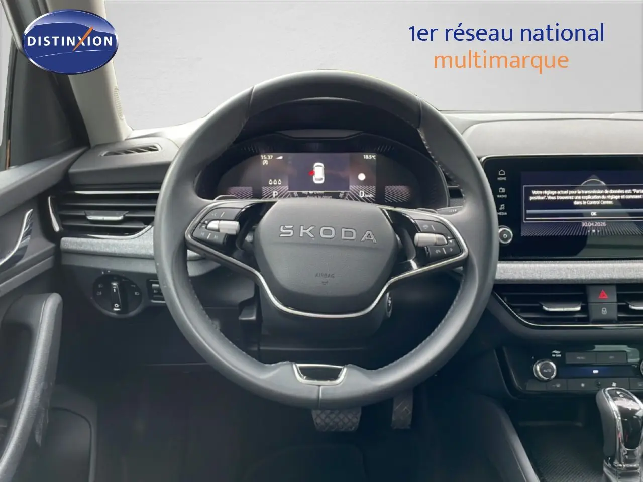 Vue intérieure centrée sur le volant SKODA d’un KAMIQ 2025, tableau de bord numérique et écran tactile visibles.