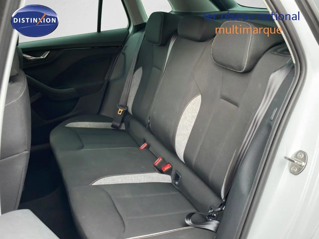 Vue intérieure côté droit montrant la banquette arrière en tissu noir avec inserts gris du Skoda Kamiq blanc glacier 2025.